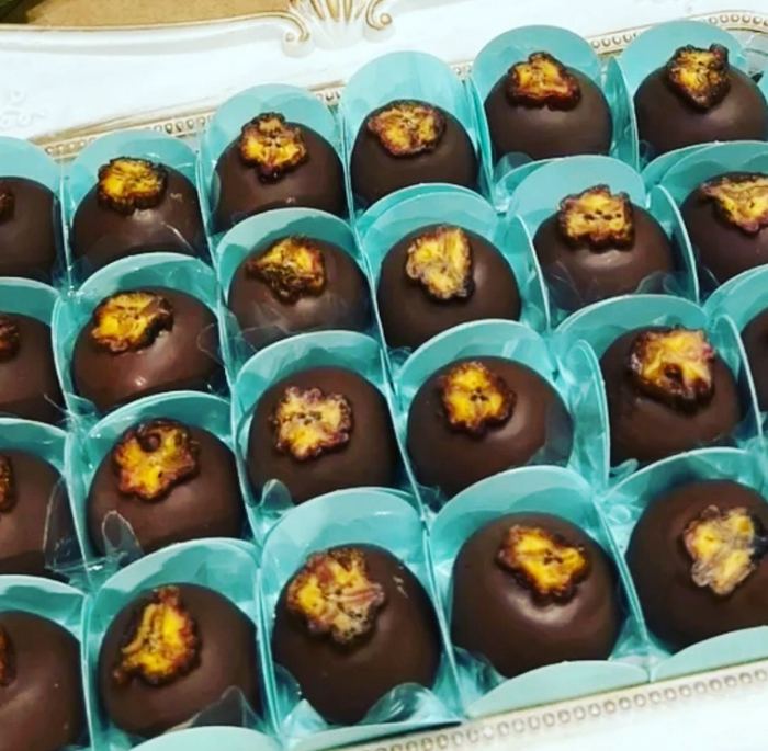 Bombons de chocolate finalizados com flor cristalizada, em forminhas azul claro