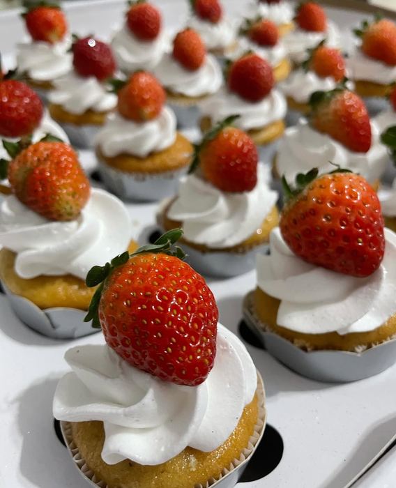 Cupcakes finalizados com chantilly e morango fresco inteiro
