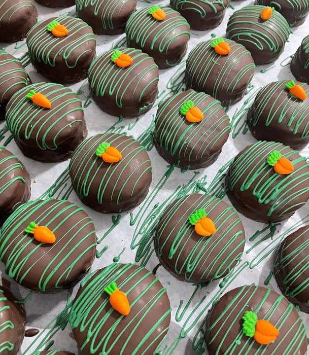 Doces de Páscoa cobertos com chocolate, fios verdes e cenoura de confeito