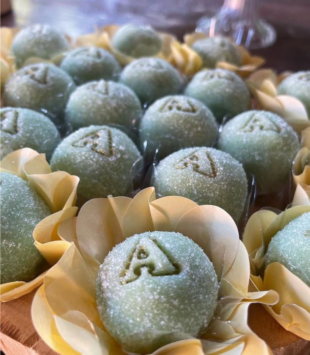Doces finos de pistache com a inicial A aplicada em dourado, em forminhas de papel — Cris Fidelis, Curitiba