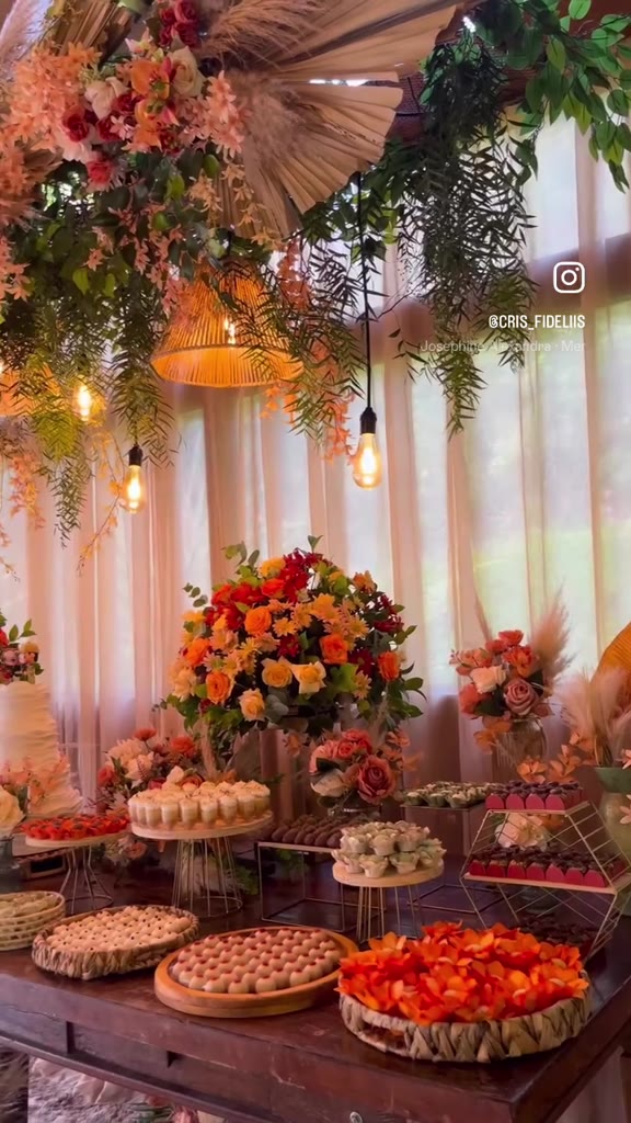 Mesa de doces com flores laranja